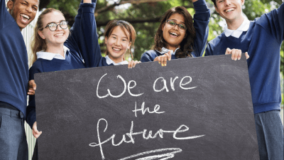 Pupils holding blackboard that reads 'We are the future'