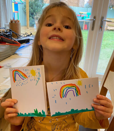 Picture of child Eloise with postcards that she has made