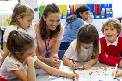 photograph of teacher interacting with group of primary-age children